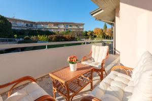 patio ze stołem i krzesłami na balkonie w obiekcie Kristall Lago 233 Apartment by Wonderful Italy w mieście Desenzano del Garda