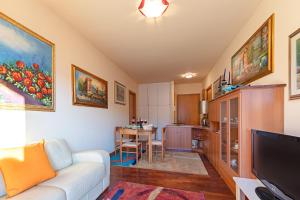 デセンツァーノ・デル・ガルダにあるKristall Lago 233 Apartment by Wonderful Italyのリビングルーム(白いソファ付)、キッチンが備わります。
