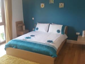 1 dormitorio con 1 cama con pared azul en The LookOut, en Skibbereen