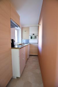 - une petite cuisine avec des placards blancs et un comptoir dans l'établissement St Honoré - Appart Design, à Arles