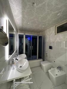 a white bathroom with a sink and a toilet at Musumeci's suite Caltagirone in Caltagirone