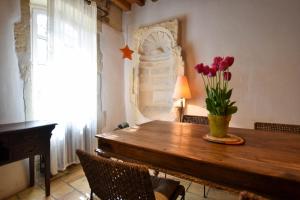 a dining room table with flowers in a vase on it at Zen Arena, Clim - Terrasse in Arles +28 photos