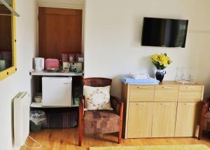 a room with a table and a chair and a tv at The LookOut in Skibbereen