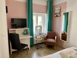a bedroom with a desk and a chair and a television at B&B Leonhard 7 in Arnoldstein