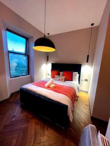 Un dormitorio con una cama grande con un animal de peluche. en Stunning 1 bed Apt in West End, en Glasgow