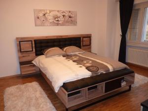 a bedroom with a large bed with a wooden headboard at RistoBar B&B al Pont in Selma