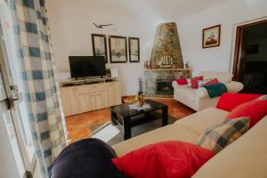 a living room with two couches and a tv at Casa Joaquina in Carvoeiro