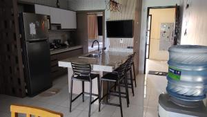 a kitchen with a counter with a bar with stools at Aquaville Resort - Terreo Nascente - Beach Park in Aquiraz