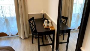 a black table and chairs in a room with a window at Foresteria Green House 1 in Seriate