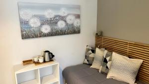 a living room with a couch and a painting on the wall at Foresteria Green House 1 in Seriate