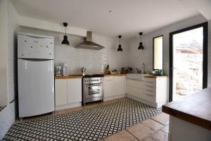 eine Küche mit einem weißen Kühlschrank und einem Herd in der Unterkunft Palmeira, Piscine - Parking - Clim in Arles