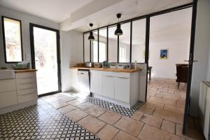 eine Küche mit weißen Schränken und einem Fliesenboden in der Unterkunft Palmeira, Piscine - Parking - Clim in Arles + 22 Fotos