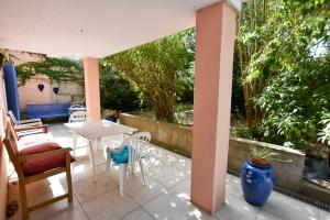 een patio met stoelen en een tafel en stoelen bij Moulin Rose, Parking - Jardin in Arles