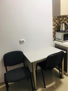 a white table and two chairs in a kitchen at Casa Famous in Iaşi