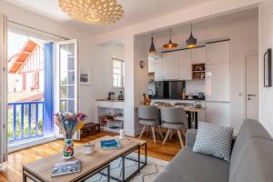 een woonkamer met een bank en een tafel bij Superbe appartement plein de charme à 5min de la plage in Biarritz