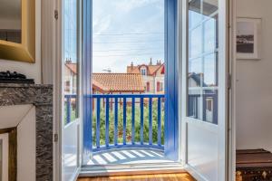 una puerta a un balcón con vistas a un edificio en Superbe appartement plein de charme à 5min de la plage, en Biarritz