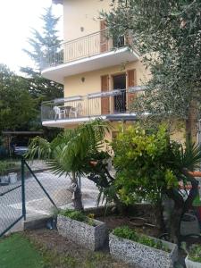 a building with a balcony and plants in front of it at Appartamento SUNRELAX in Riva del Garda