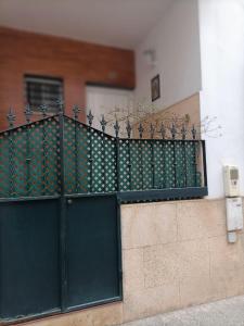una puerta negra con plantas al lado de un edificio en Casa Flamenca en Castilleja de la Cuesta