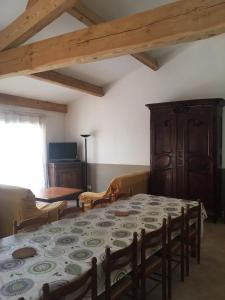 un comedor con mesa y sillas y una habitación con ventana en Gite Sainte Octime, en Sardan