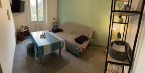 niewielka sypialnia z łóżkiem i stołem w obiekcie appartement à Tarascon sur Ariège le Sabart w mieście Tarascon-sur-Ariège
