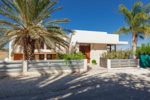 a house with a white fence and palm trees at Alkistias & Konstantinos Villa in Lachi