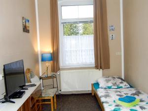 a bedroom with a bed and a desk and a window at Ferienwohnung Gluehwuermchen in Barnin +14 photos