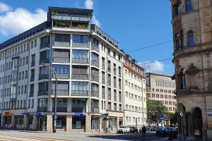a tall white building with a balcony on the side of a street at Laurin Apartment L62 in Dresden
