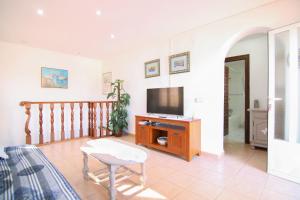 a living room with a tv and a table at Villa Maryvilla 0210 in Calpe