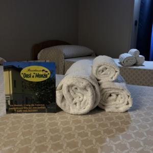 a pile of towels sitting on top of a bed at Residence Oasi Di Monza in Monza