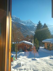 una casa en la nieve con una montaña en el fondo en La Chaine du Mont-blanc, en Chamonix-Mont-Blanc