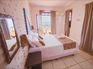 a bedroom with a bed and a view of the ocean at Hotel Platô in Paraipaba