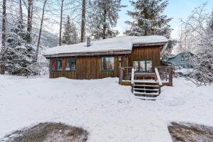 a small cabin in the snow with a snow covered roof at Cedar Chalet on Davos in Girdwood