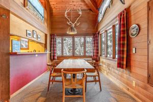 a dining room with a wooden table and chairs at Cedar Chalet on Davos in Girdwood