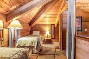Habitación con 2 camas en una cabaña de madera en Cedar Chalet on Davos, en Girdwood