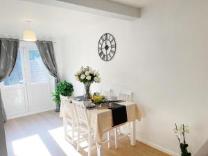 a dining room with a table and chairs and a clock on the wall at Oxford city centre house/walkable to University in Oxford