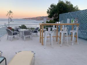 a group of chairs and tables on a patio with the ocean at Apartment Villa Loula in Poros
