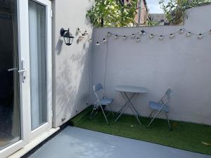 un pequeño patio con 2 sillas y una mesa en Large House Near Anfield & Liverpool Town en Liverpool