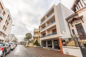 un edificio in una strada con auto parcheggiate di STANDING THERMES - Confort - Proche Thermes & Bords d'Allier a Vichy