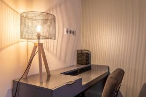 una scrivania con lampada e sedia in camera di STANDING THERMES - Confort - Proche Thermes & Bords d'Allier a Vichy