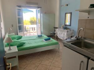 a room with a bed and a kitchen with a sink at Apartment Villa Loula in Poros +26 photos