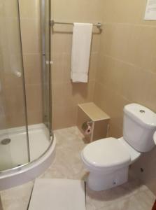 La salle de bains est pourvue d'une douche et de toilettes blanches. dans l'établissement Yria Residencial, à Porto Novo