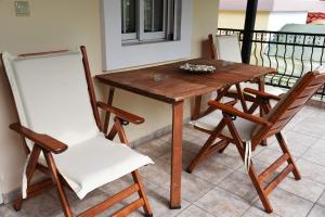 a wooden table with two chairs and a table at Summer Panorama Retreat - Yard, Barbeque, up to 7 in Epanomi