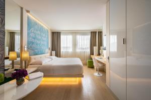 una habitación de hotel con una cama y un escritorio en N’vY Manotel, en Ginebra