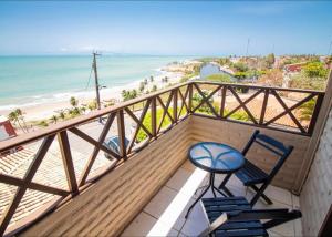 a balcony with a table and chairs and the beach at Hotel Platô in Paraipaba