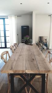 een grote houten tafel in een kamer met stoelen bij Muntershof in Velzeke-Ruddershove