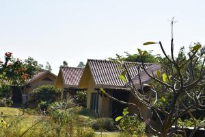 une maison au milieu d'un jardin dans l'établissement WelcomHeritage Tadoba Vanya Villas Resort & Spa, à Kolāra