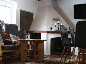 a living room with a table and chairs and a fireplace at Penzion Maruška in Dolní Moravice