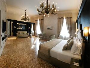 a bedroom with a large bed and a chandelier at Hotel Aquarius Venice - Ascend Collection in Venice