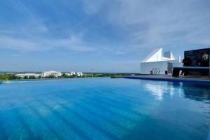 a large swimming pool next to a white building at Imperio Homestay Alor Star in Alor Setar