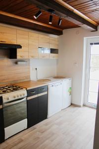 una cocina con electrodomésticos blancos y armarios de madera en Penzion Maruška, en Dolní Moravice